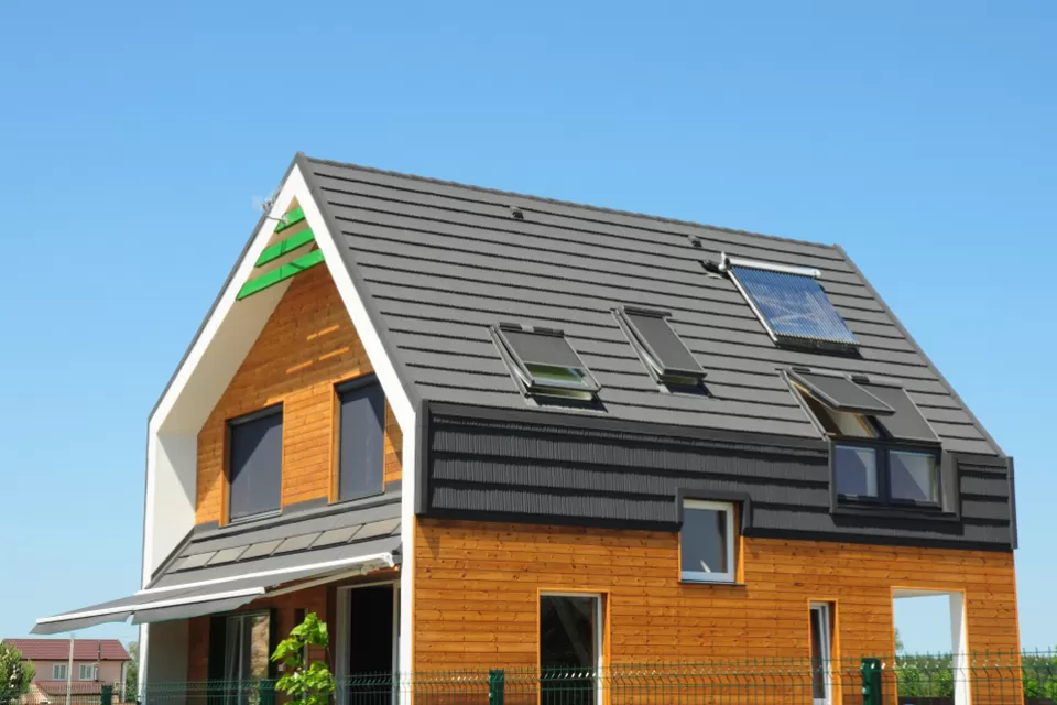 Modern Passive House Exterior. Modern energy efficiency house with skylight windows and solar panels on the roof top.